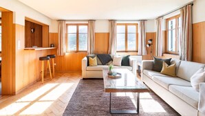 A living room with a sofa, coffee table, and a wooden wall with a mounted deer head. - Apartment 1, comfort and comfort (4 Edelweiss) - Haus Kammern 168 (Egg)