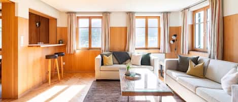 Un salon comprenant un canapé, une table basse et un mur en bois orné d’une tête de cerf fixée au mur.