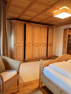 A wooden bedroom with a bed, a chair, and a wardrobe. - House in Kammern: Top-Notch Property with Spacious 100 m² of Comfort and a Balcony with Mountain Views - House (Egg)