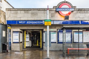 A London Underground station entrance with a sign for West Kensington. - Magic Properties (London)