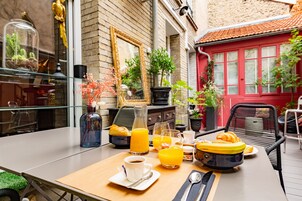 A breakfast table with orange juice, croissants, and coffee.