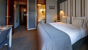 A hotel room with a large bed, a desk, a bathroom, and a striped wall. - Hôtel Azur Reims (Reims)