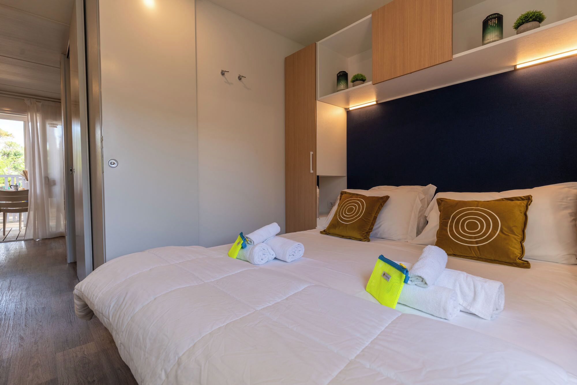 A hotel room with a large bed, a wardrobe, a desk, and a view of the outdoors.