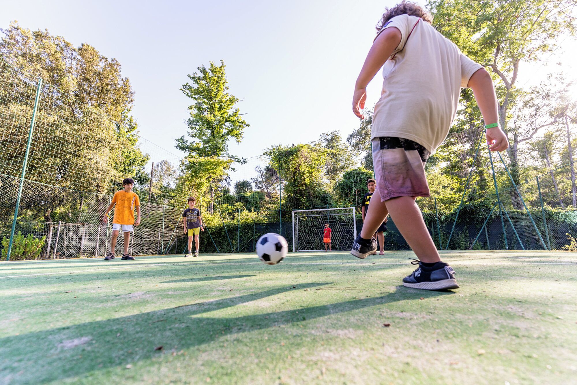 Un campo de fútbol con un arco, una red y jugadores.
