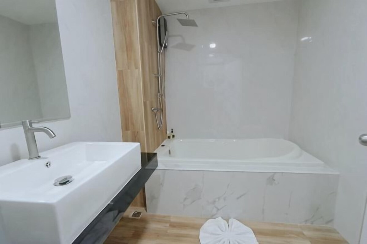 A bathroom with a white sink, a bathtub, and a shower.