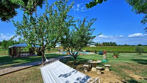 Un jardin avec un hamac, un kiosque et une piscine.