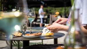A dining table with a glass of white wine, a plate with a pastry, and a bottle of water. - Conscious Hotel Westerpark (Amsterdam)