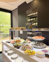 Un bufé con diversas opciones de comida, incluyendo mariscos, ensaladas y frutas.