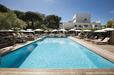Una piscina al aire libre de temporada, sombrillas