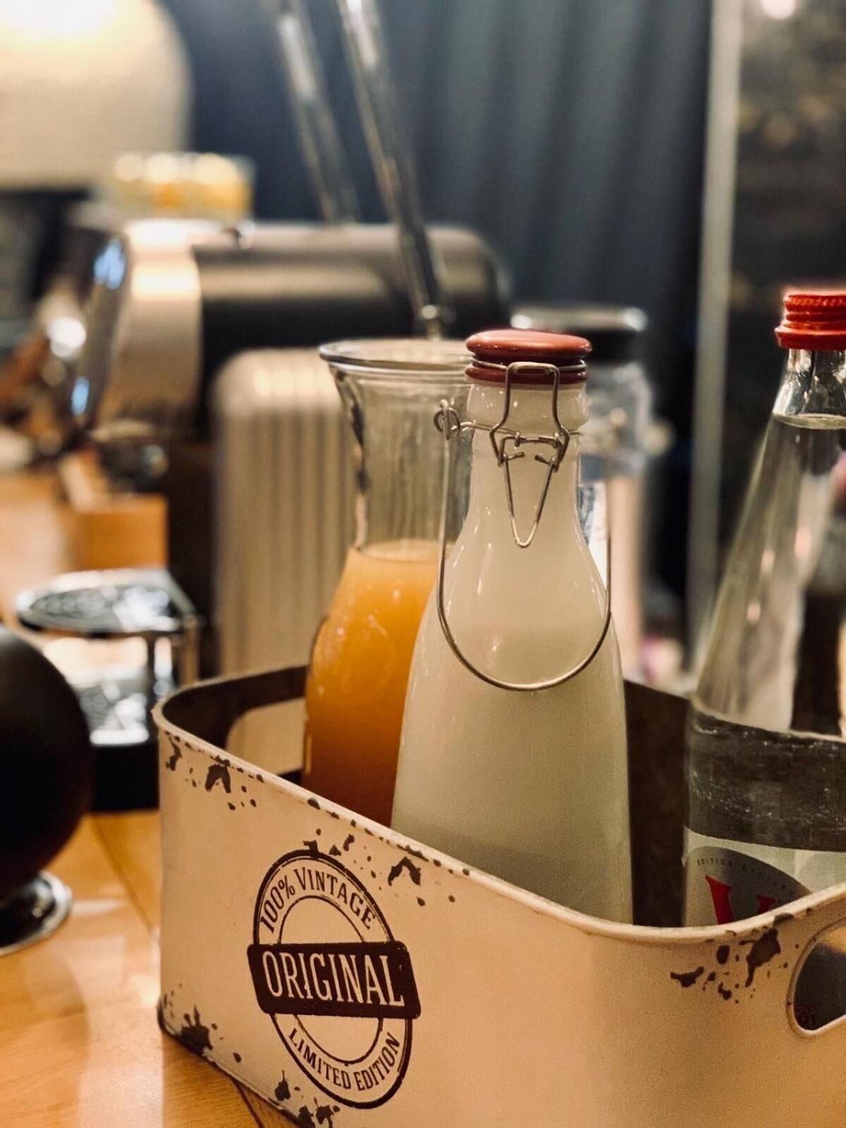 Eine alte Milchflasche in einem Metallbehälter mit dem Aufdruck '100% Vintage Original Limited Edition'.