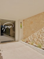 Entrada de un hotel con pared de piedra y puerta de cristal.