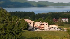 Zona residencial con casas cerca de un lago, rodeada de vegetación y colinas.