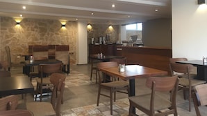 A restaurant with stone walls, wooden furniture, and a bar area.