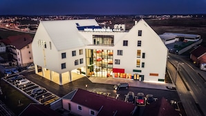 A modern hotel with a prominent sign reading "HOTEL GARDEN HILL".