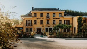A two-story building with a yellow facade, labeled "Hotel" and "Restaurant" on the upper floor. - Hotel-Restaurant Le Cigalon (Waldbillig)