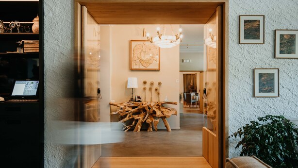 A modern interior with a wooden coffee table, a chandelier, and framed artwork on the walls. - Hotel-Restaurant Le Cigalon (Waldbillig)