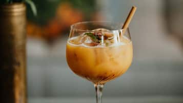 Een glas ijsthee met een rietje op een houten ondergrond.
