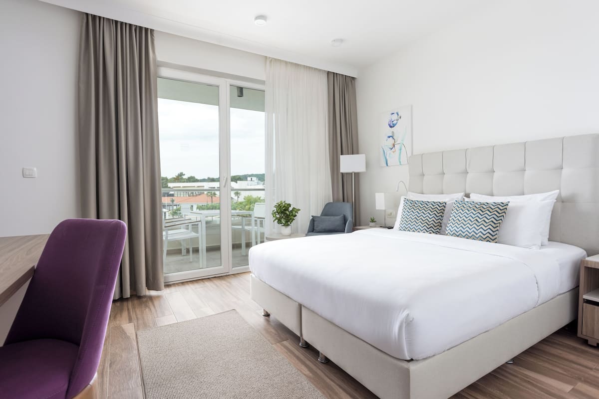 Een moderne hotelkamer met een groot bed, een bureau en een stoel.