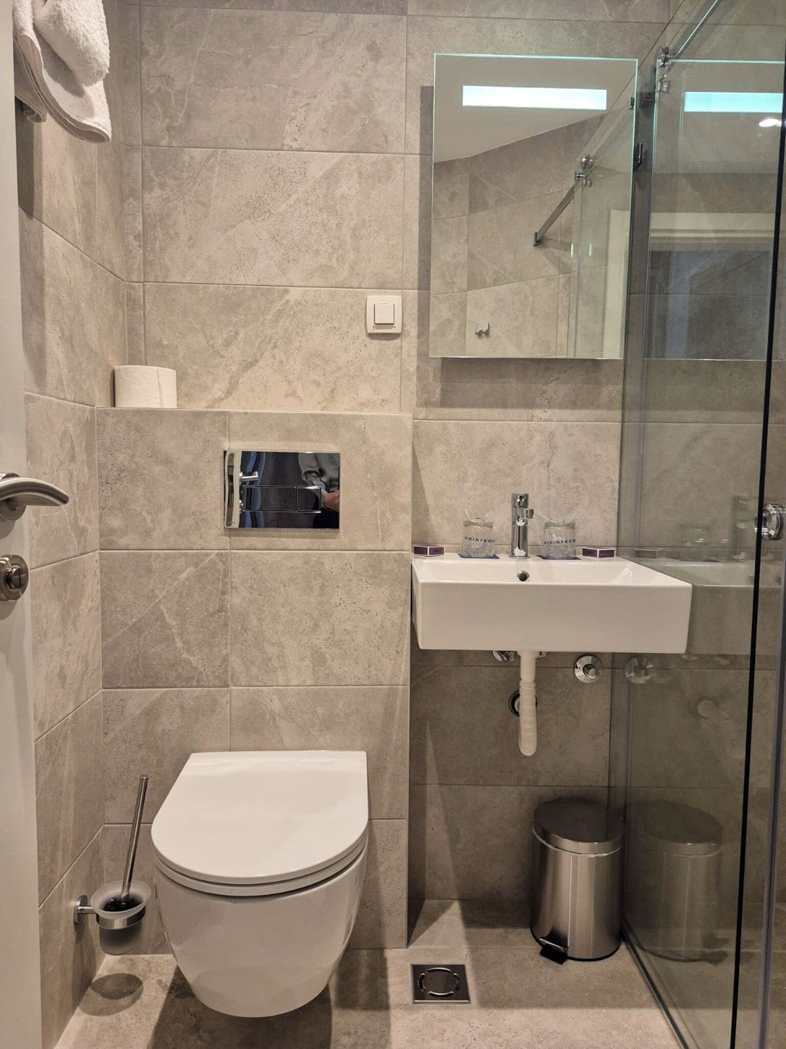 Ein modernes Badezimmer mit Toilette, Waschbecken und Duschkabine.