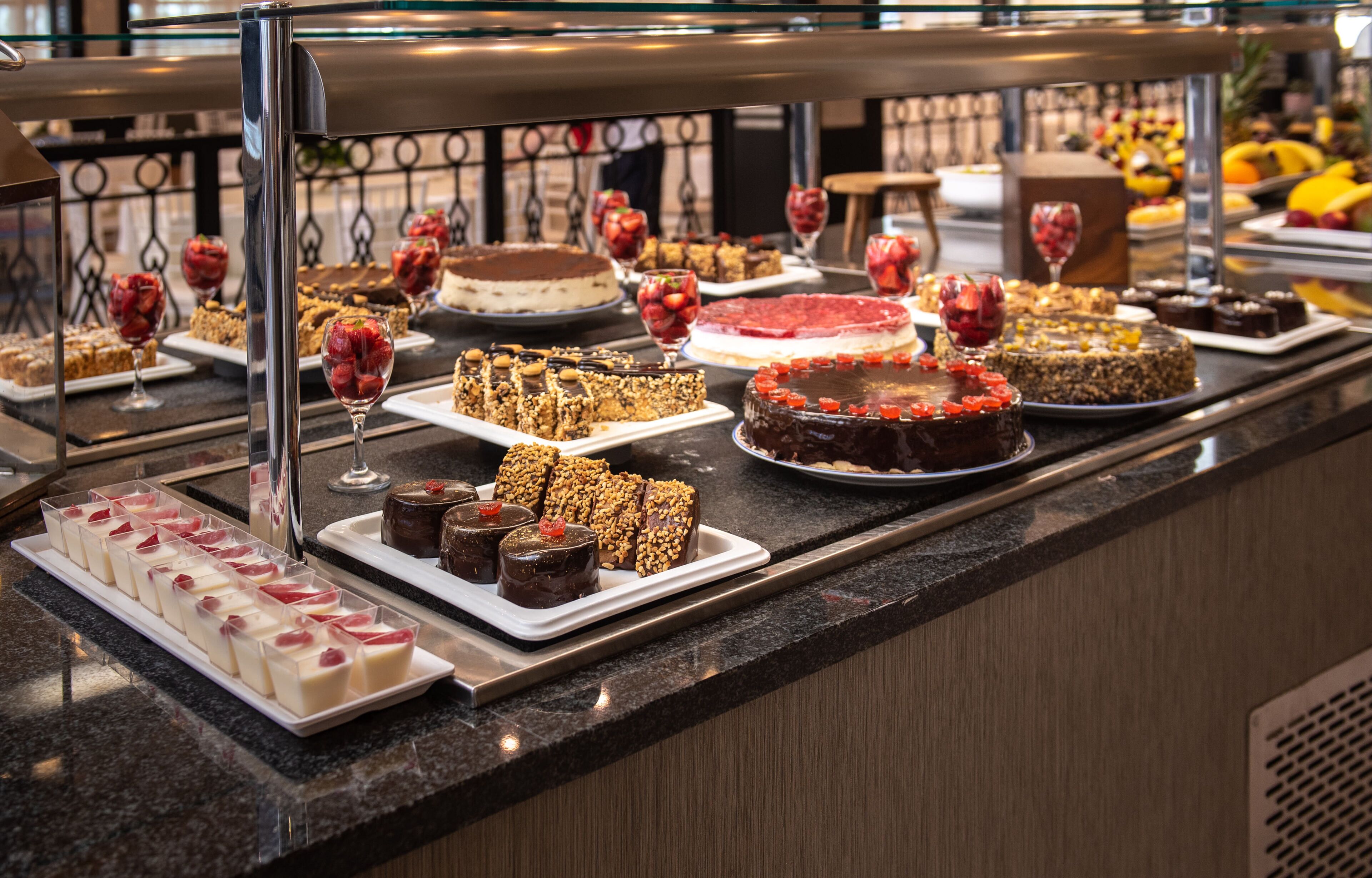 A buffet with various desserts and fruits.