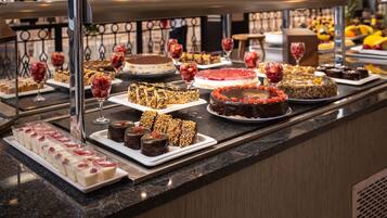 A buffet with various desserts and fruits.