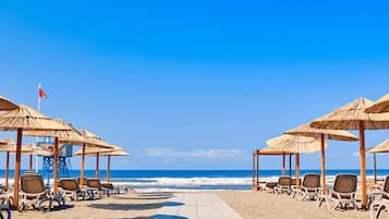 On the beach, sun-loungers, beach umbrellas, beach towels