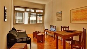 Una habitación con una mesa de comedor de madera, sillas, un sofá y un ventilador de techo.