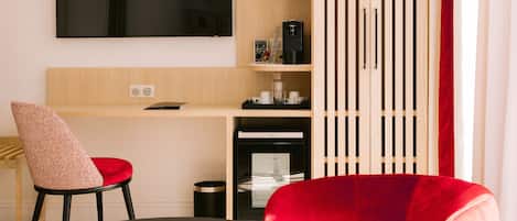 A modern living room with a red chair, a black table, and a wooden cabinet with shelves.