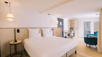 A modern hotel room with a large bed, bedside tables, a desk, and a chair.