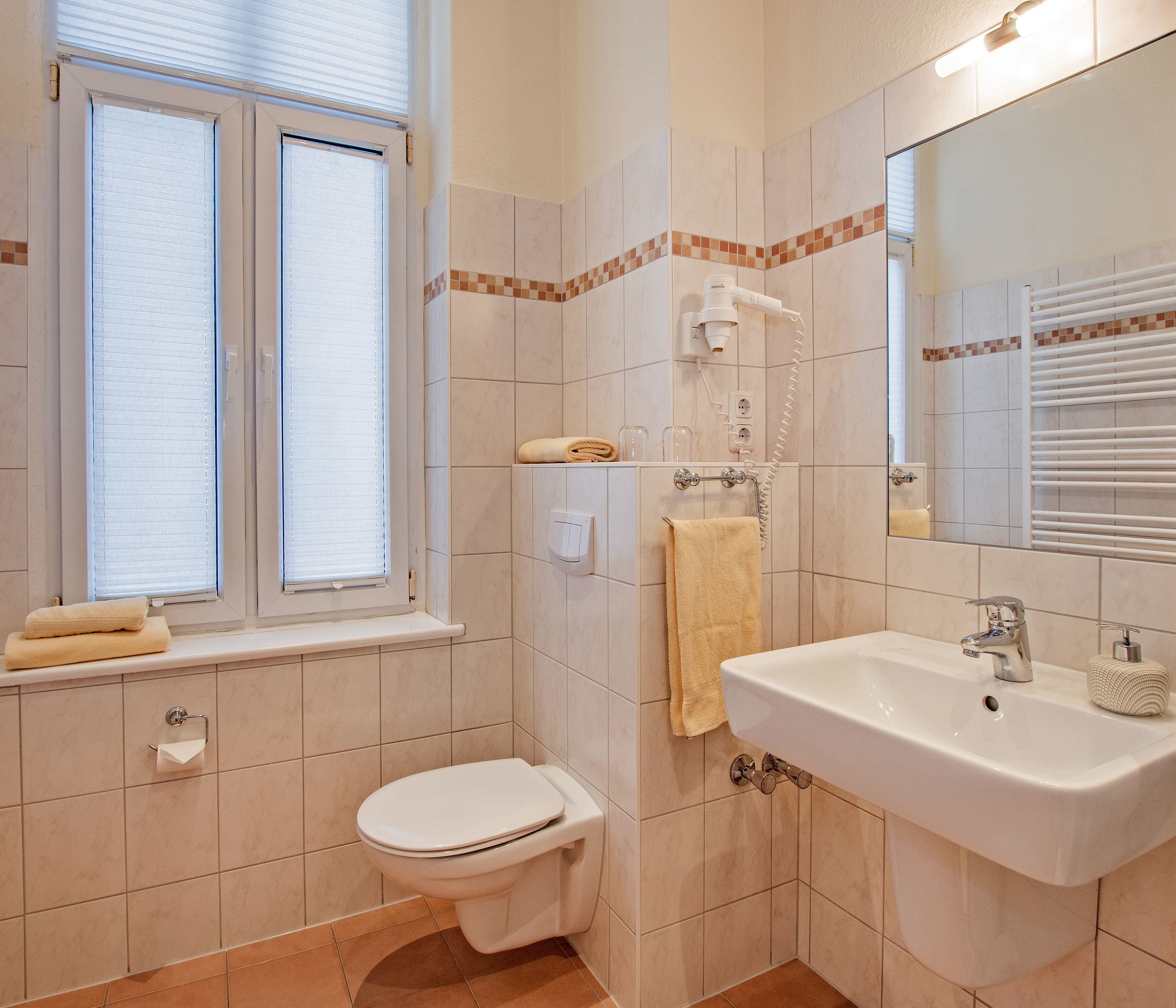 Un baño con inodoro, lavamanos y ventana.
