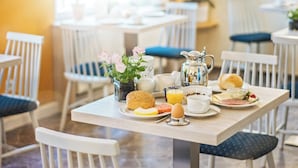 Une table de petit-déjeuner avec une variété d’aliments, notamment des œufs, des toasts et une boisson.