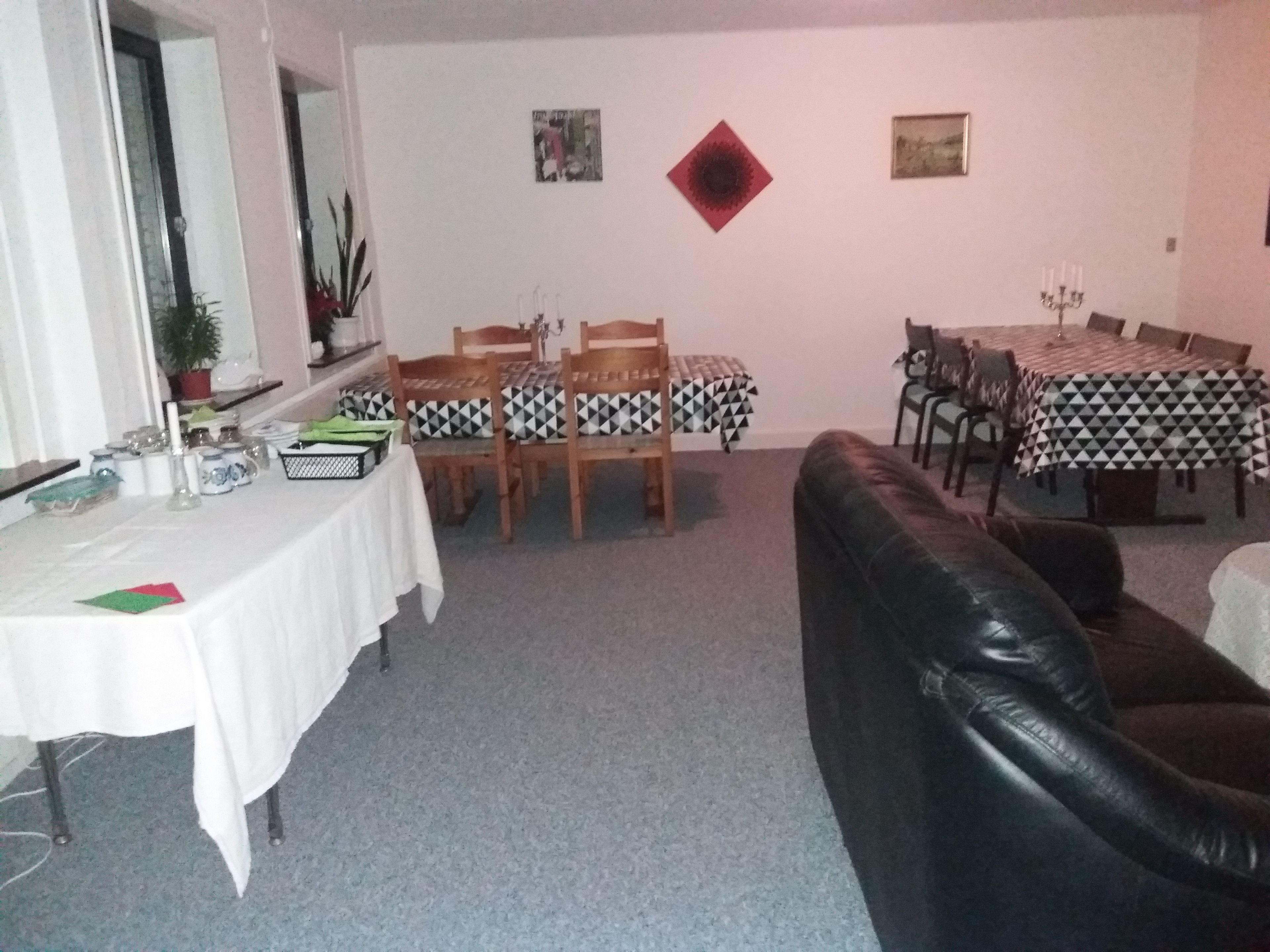 A dining area with a table set for four, surrounded by chairs with patterned tablecloths.