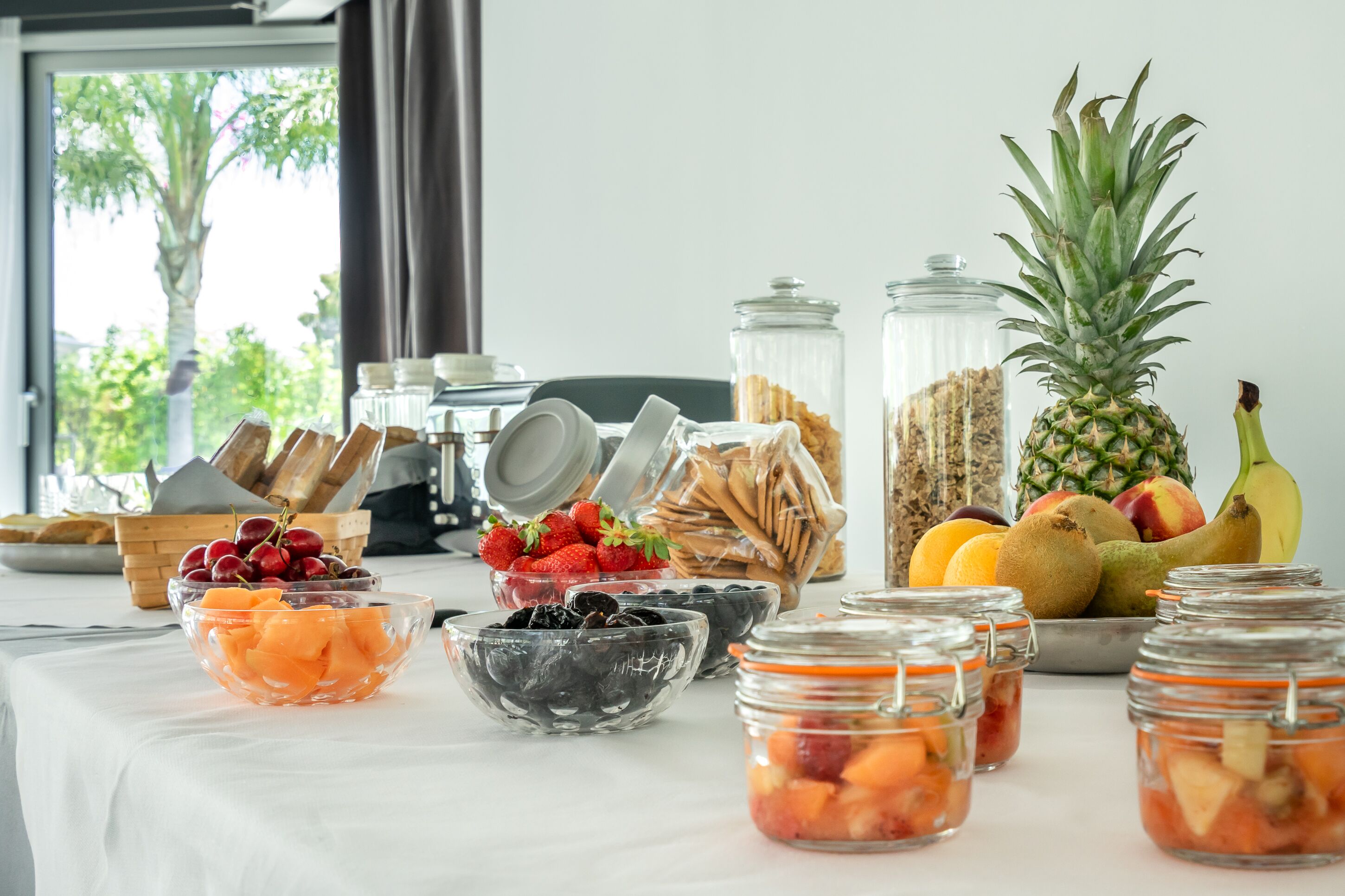 Un buffet de petit-déjeuner proposant une variété de fruits, de pains et de condiments.