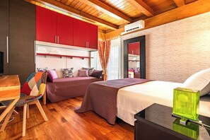 Un dormitorio moderno con dos camas, techo de madera y un armario rojo.