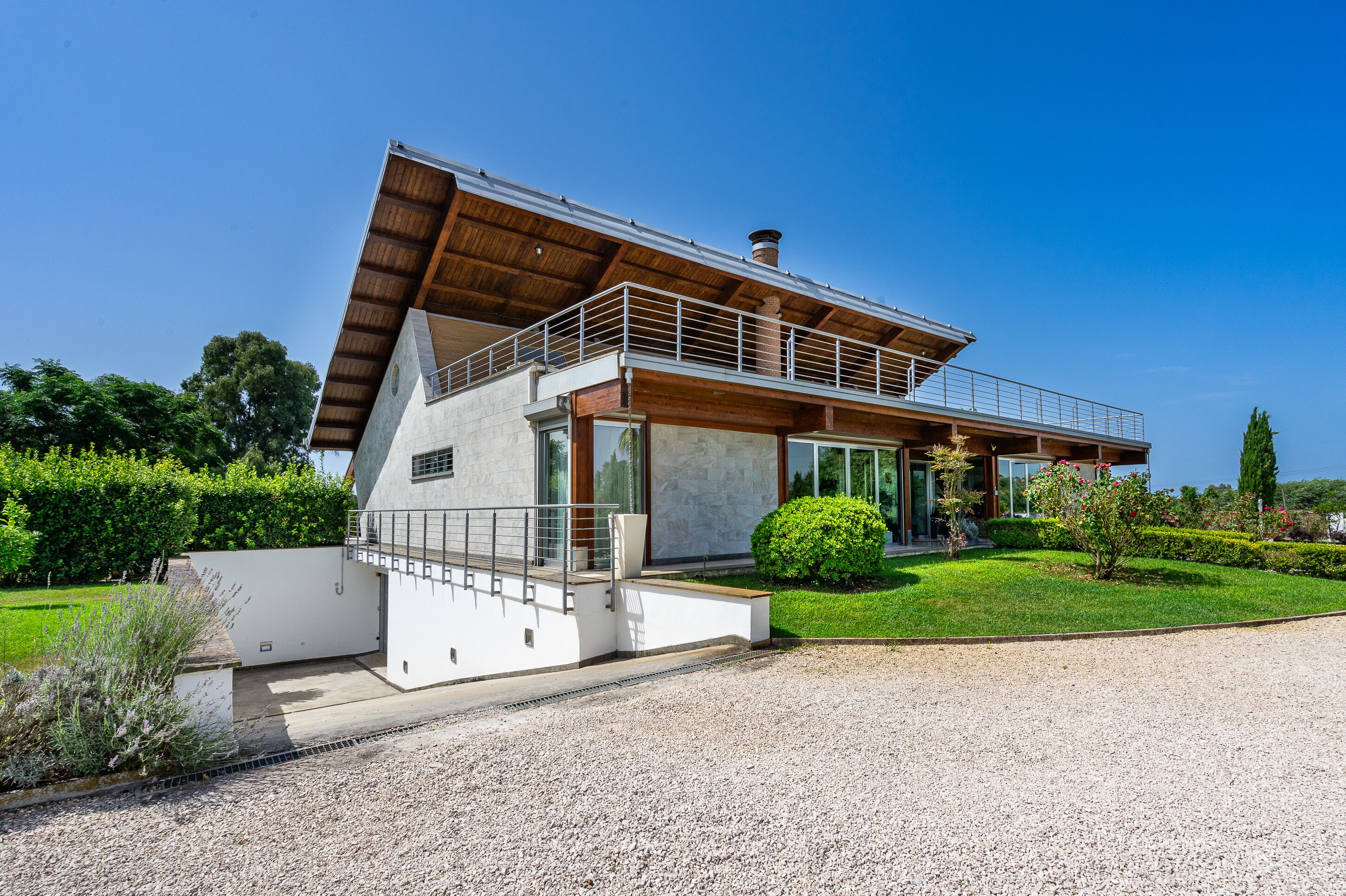 A modern house with a sloped roof, large windows, and a balcony.