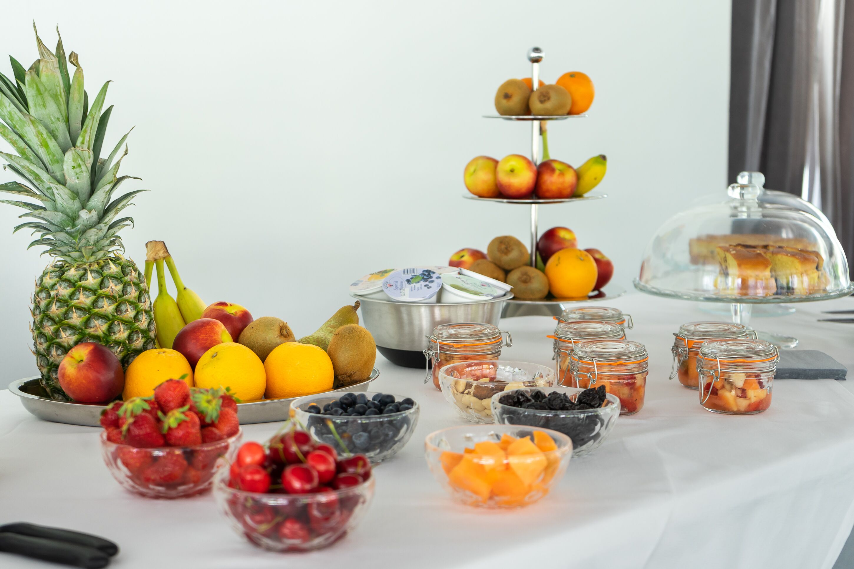 Una taula amb diverses fruites i un aparador de tres nivells.