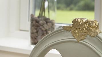 Ein Fenster mit Blumen in einer Vase und einem Holzstapel.
