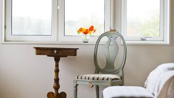 Una habitación con ventana, una mesa, una silla y una cama.