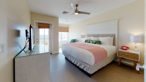 A hotel room with a bed, a desk with a computer, a telephone, and a ceiling fan. - The Hotel Maria (Westerly)