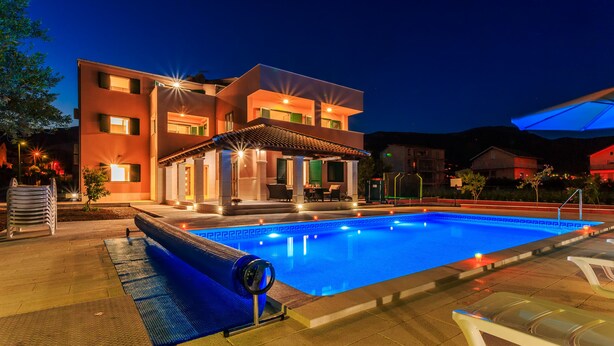 A modern two-story building with a swimming pool and outdoor seating area. - Villa Rusula (Kastela)