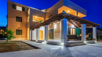 Vista frontal de la propiedad por la tarde o noche