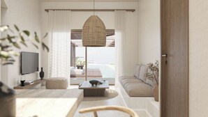 A modern living room with a TV, a dining table, and a sofa. - Thalasses Villas Rethymno (Rethymno)