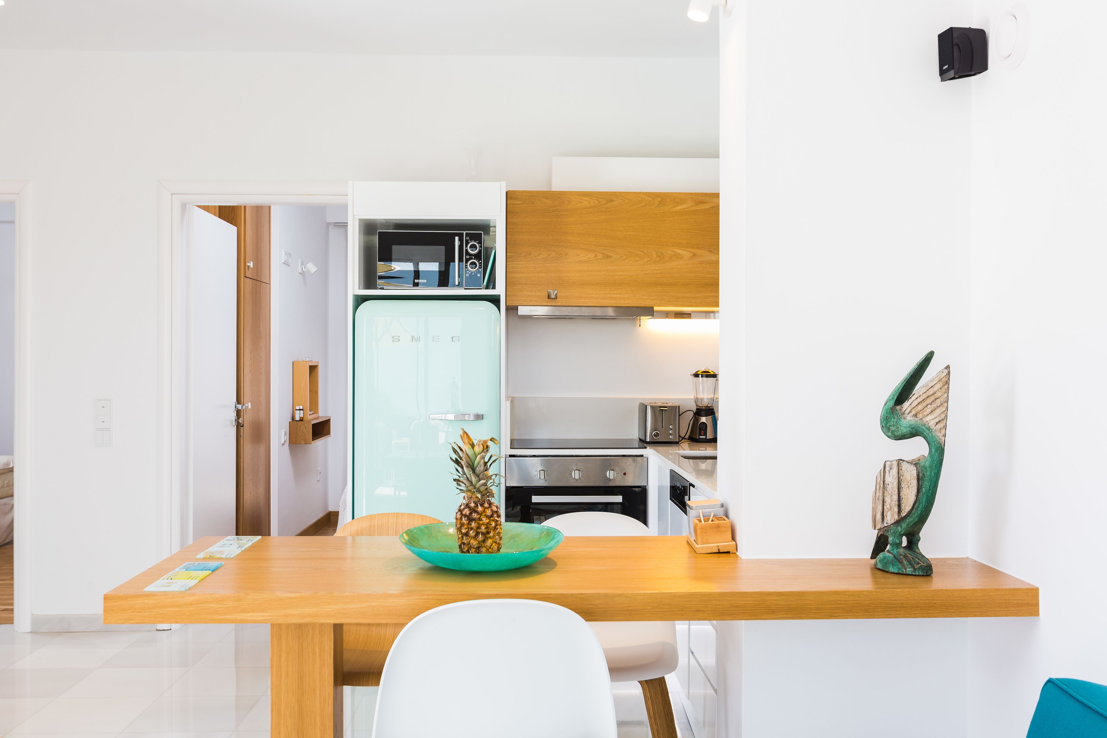 A modern kitchen with a wooden countertop, a microwave, and a blender.