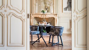 A dining area with a table set for two, ornate wall paneling, a fireplace, and a chandelier. - La Villa Guy & Spa - Teritoria (Béziers)