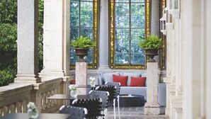 A sunlit interior with a seating area, columns, and large windows with stained glass. - La Villa Guy & Spa - Teritoria (Béziers)