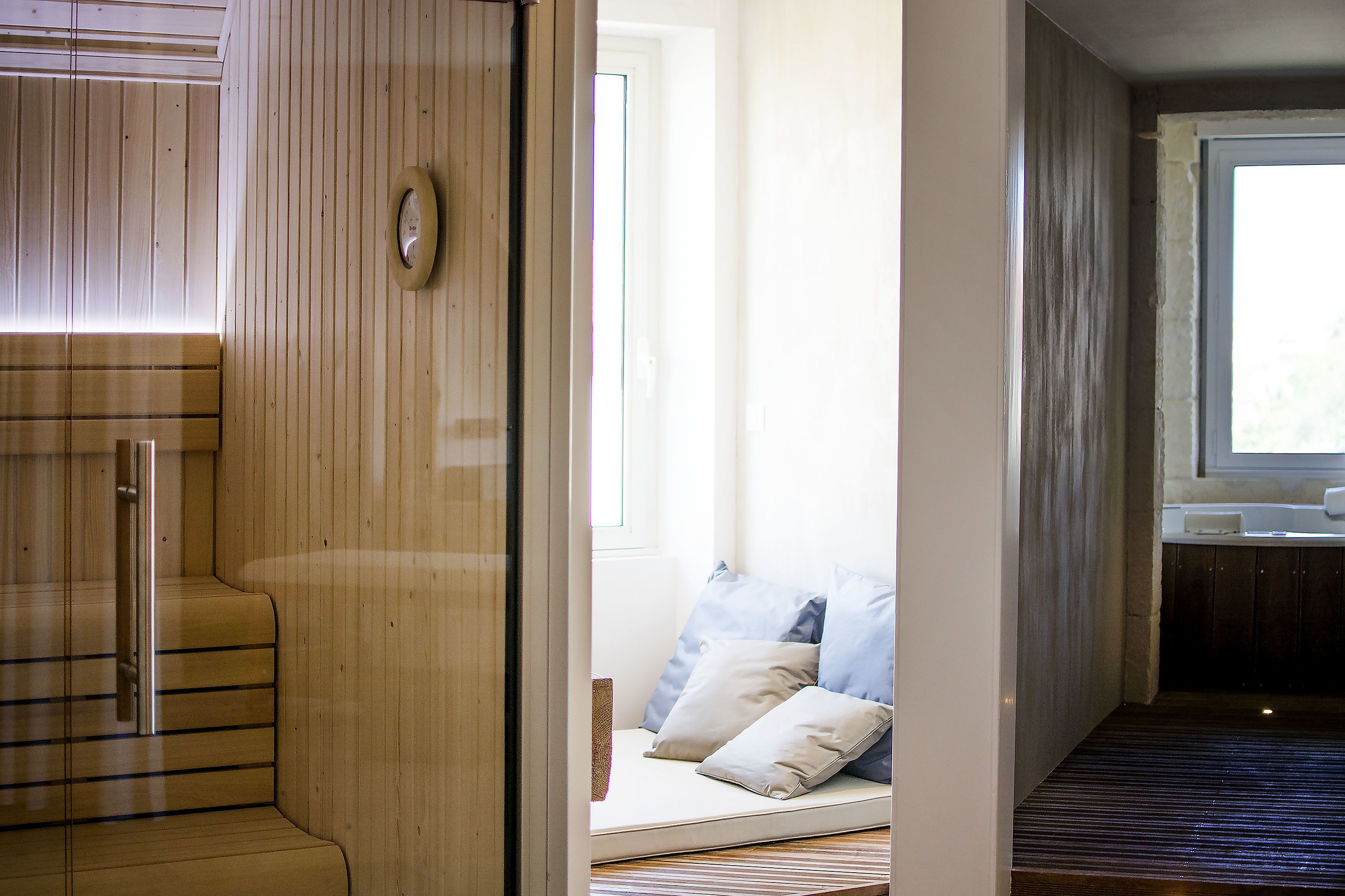 Un intérieur en bois avec un banc, une petite table et une fenêtre.
