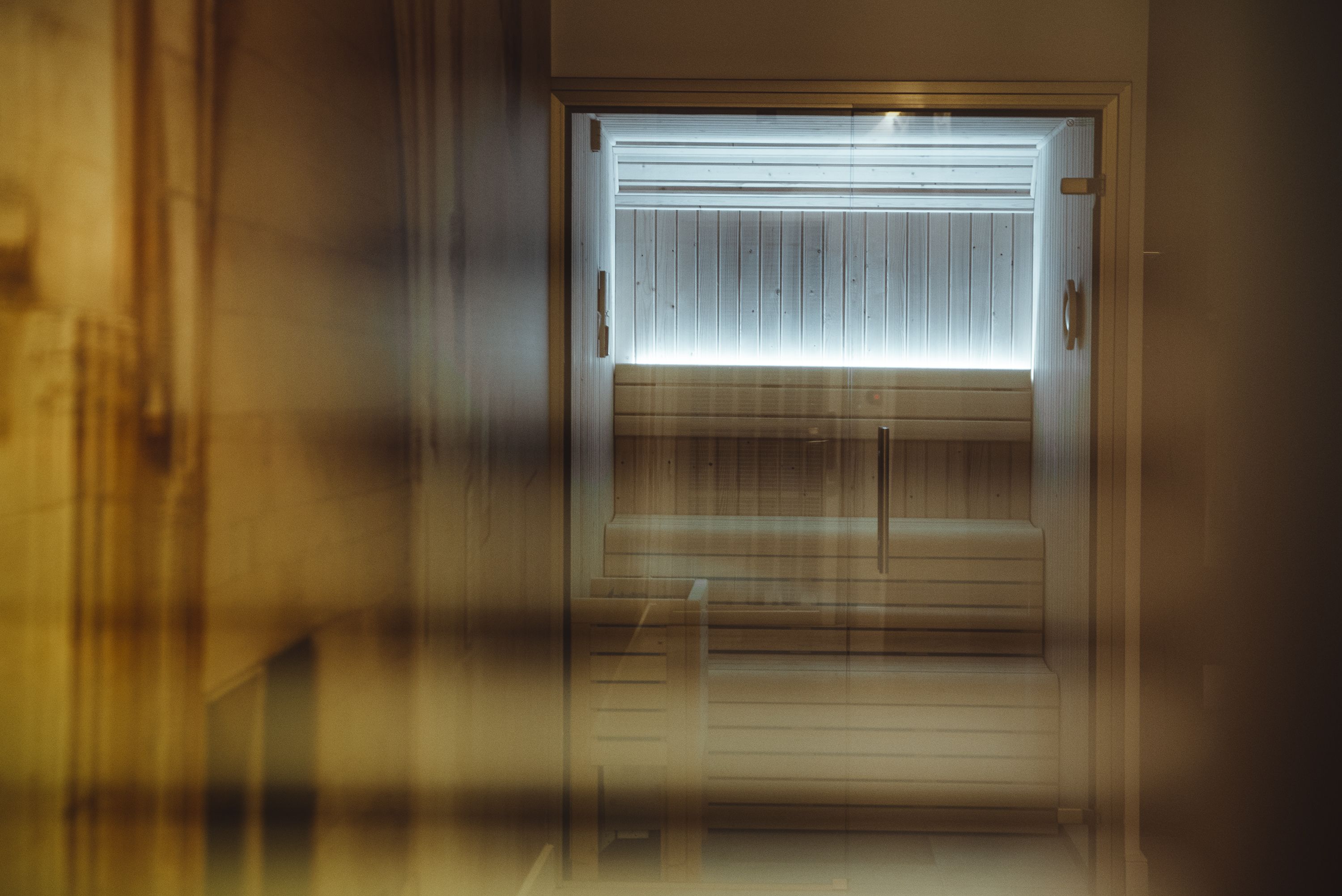 A doorway with a frosted glass panel and a wooden door.