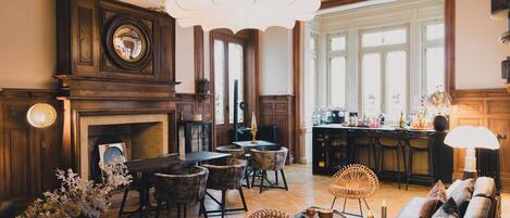 A spacious living room with a fireplace, dining area, and kitchen.