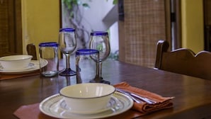 A dining table with plates, glasses, and a folded napkin.