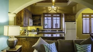 A cozy kitchen with wooden cabinets, a central island, and a dining area with a sofa.